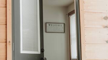 Une porte en bois avec une pancarte « BIENVENUE » au-dessus.