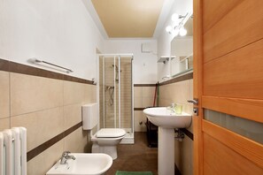 Un baño con ducha, inodoro, lavabo y bidé.