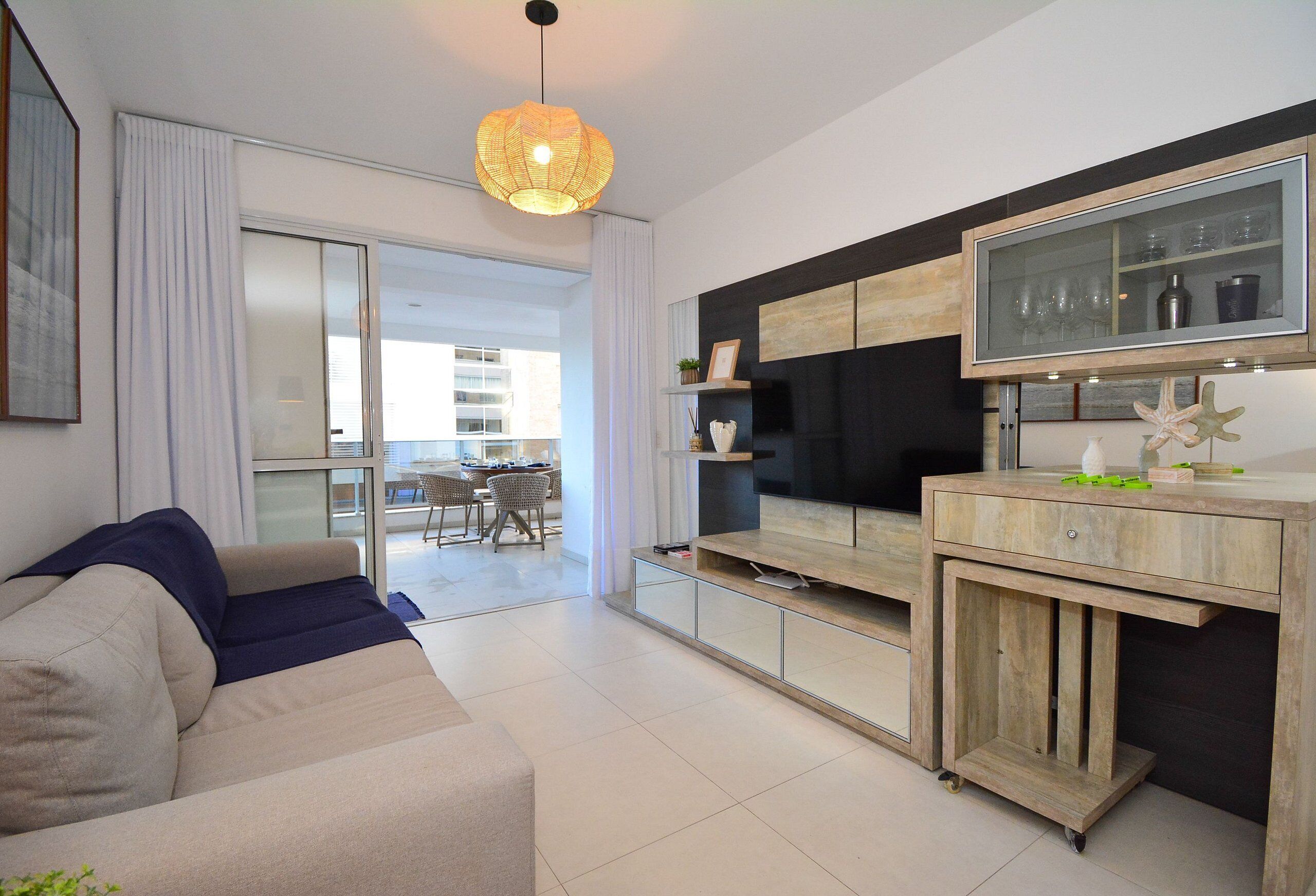 A modern living room with a sofa, a TV, and a wooden cabinet.