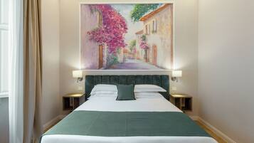 Een hotelkamer met een groot bed, twee nachtkastjes, een hoofdbord en een schilderij van een straatbeeld.