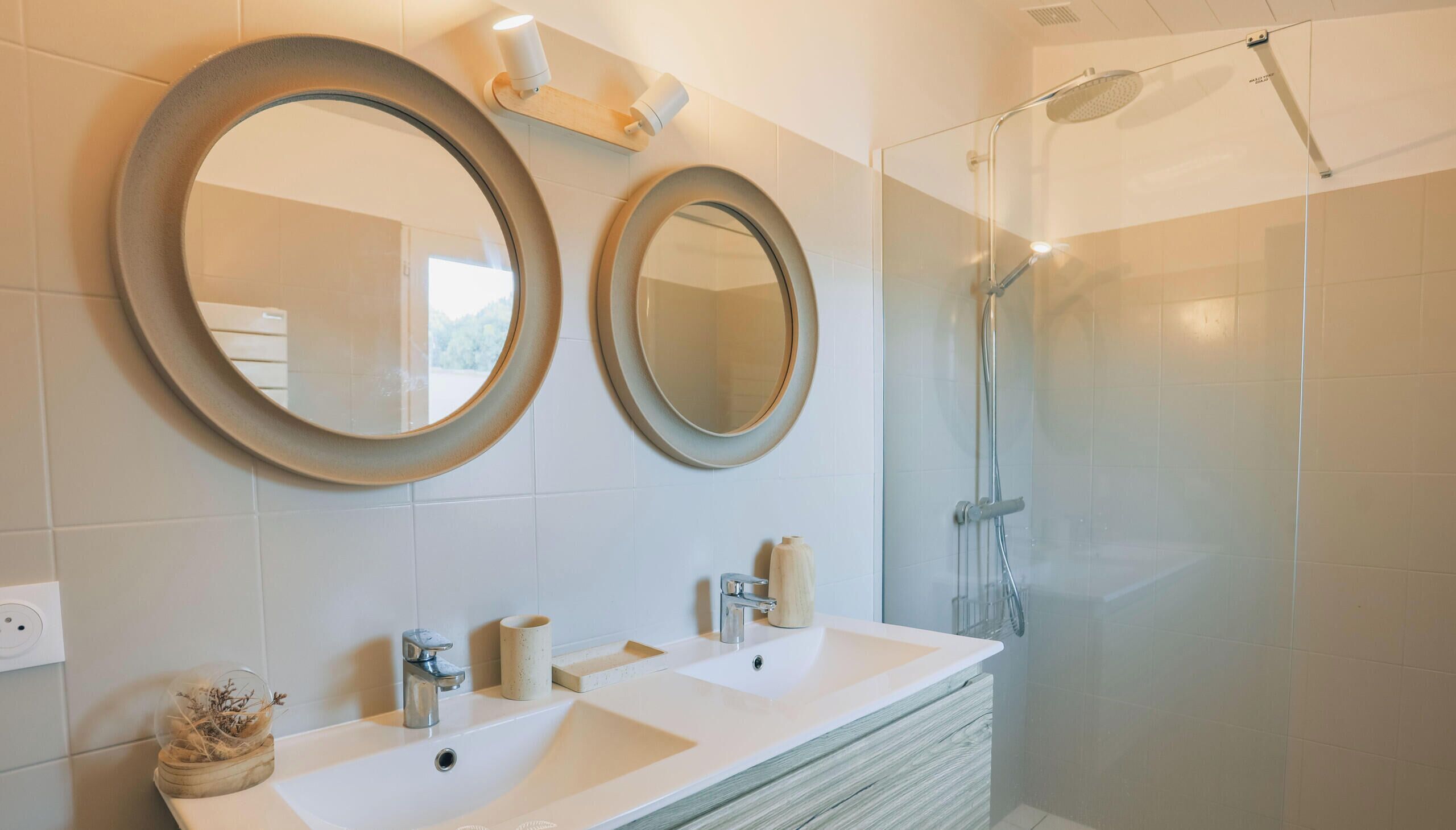 Un baño con dos lavamanos, dos espejos, ducha e inodoro.