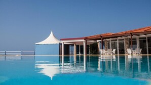 A clear blue pool with a white tent and lounge chairs. - Studio Murdeira Side Beach Ecologic Protected Bay, Snorkling include, Pool (Ilha do sal)