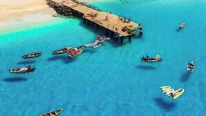 An aerial view of a coastal area with a pier extending into turquoise waters, surrounded by boats and a beach with buildings in the background. - Studio Murdeira Side Beach Ecologic Protected Bay, Snorkling include, Pool (Ilha do sal)