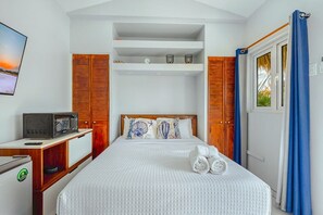 A hotel room with a bed, a television, a desk, and a wardrobe. - EVA Aruba Boutique Resort & SPA (Savaneta)