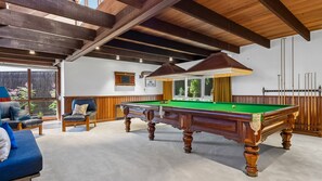 A pool table in a room with wooden beams, a sofa, and a chair. - Somerset - Portsea - Coastal Escape with Private Beach Access (Portsea)