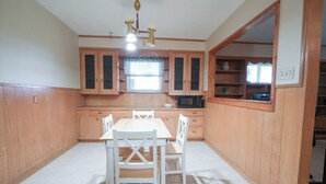 A kitchen with wooden cabinets, a white dining table, and chairs.