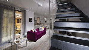 Ein modernes Wohnzimmer mit einem violetten Sofa, einem Schachbrett und einer Treppe.