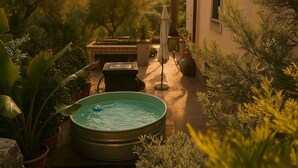 A hot tub in a garden with potted plants and a brick fireplace. - OLD RENOVATED COTTAGE NESTLED IN THE COUNTRYSIDE WITH GARDEN/RELAXATION CORNER (Adrano)