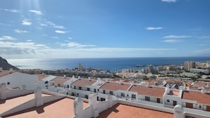 A coastal cityscape with white buildings and red-tiled roofs, a clear blue sky, and the sea in the background. - Port Royale Ocean Views Los Cristianos (Los Cristianos)