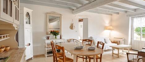 Un comedor con una mesa de madera, sillas y un armario blanco.