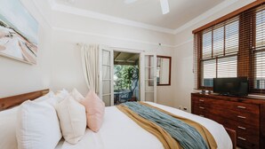 A bedroom with a bed, a television on a wooden dresser, and a window with blinds. - A Market Place Mudgee Walk to Town Centre and Parks (Mudgee)