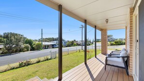 Eine überdachte Veranda mit Blick auf eine Straße und Häuser.