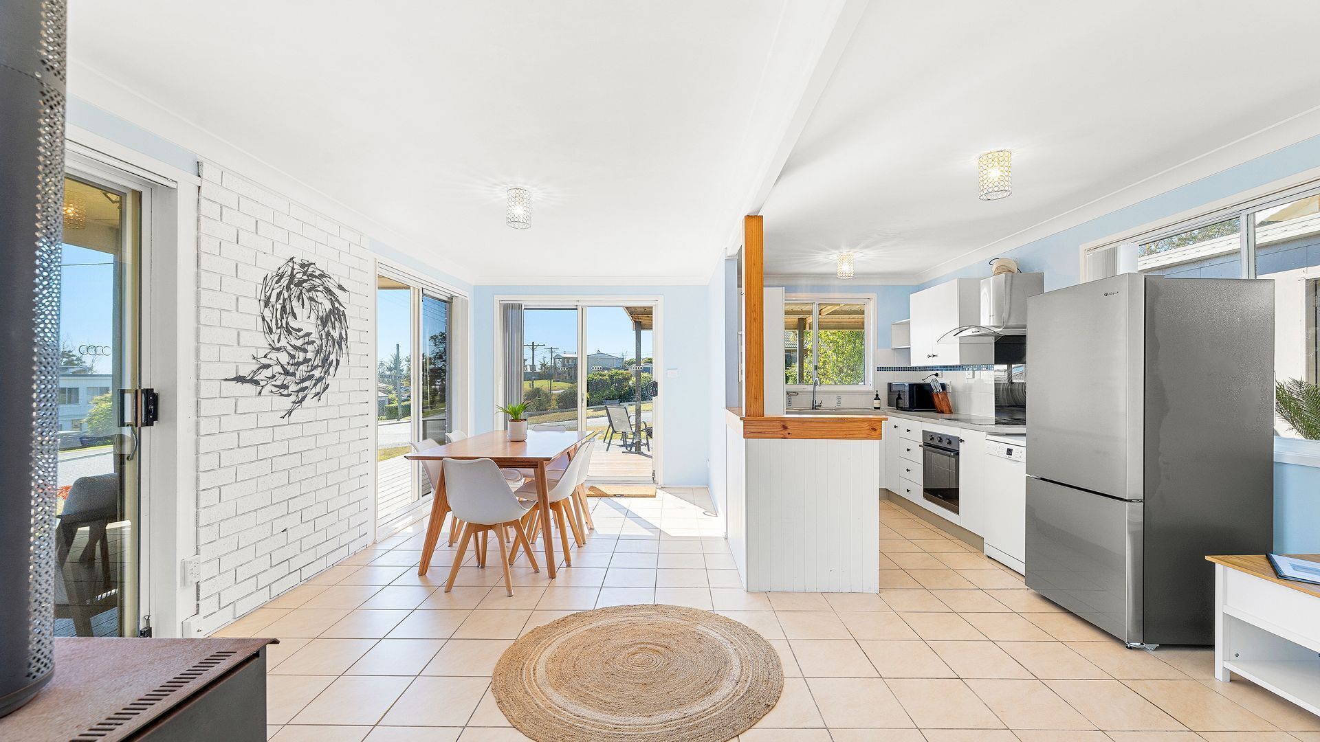 A modern kitchen with a central island, white cabinetry, and stainless steel appliances.