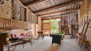 A rustic room with a pool table, wooden furniture, and a large window. - Gîte L'Etable - Les Gites Du Moulin: private terrace, garden, Wi-Fi in Saint-Hilaire-la-Palud (Saint-Hilaire-la-Palud)