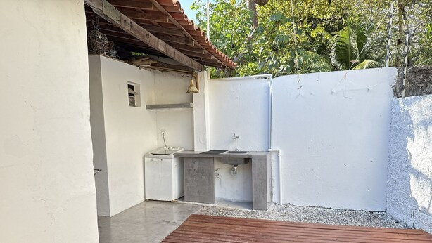 A small outdoor area with a wooden deck, a washing machine, and a sink. - Oceana Suites Vila Cajarana (Tibau do Sul)
