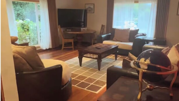 A living room with a sofa, armchairs, a coffee table, a TV, and a dining table. - Delightful 4-bedroom house in peaceful Connemara Countryside (Moycullen Galway)