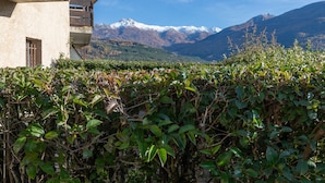 A building with a balcony overlooking a mountainous landscape.