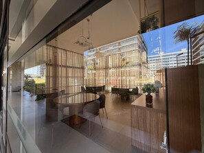 A modern interior with a glass partition, a round dining table, and chairs. - Noroeste design comfort and charm (Brasília)