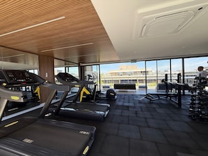 A gym with treadmills, a stationary bike, and weight equipment. - Noroeste design comfort and charm (Brasília)
