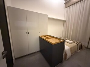 A compact bedroom with a wardrobe, a bed, and a small wooden table. - Noroeste design comfort and charm (Brasília)
