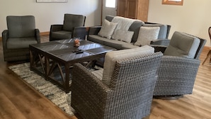 A living room with wicker furniture, a wooden coffee table, and a map on the wall.