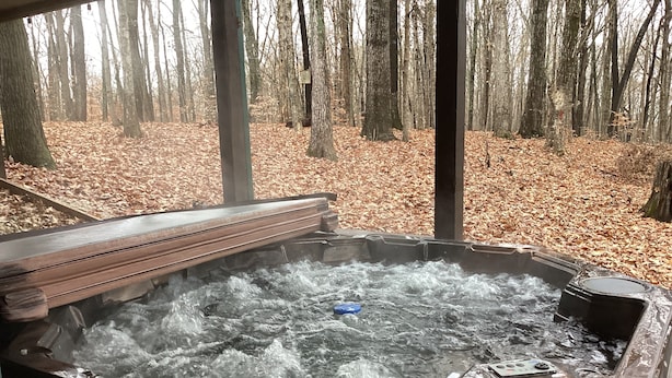 A hot tub with a view of a forest.