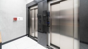 Un ascensor modern amb taulell de control i botó d'emergència.