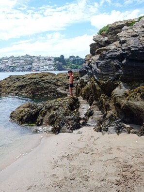 A rocky beach with a person standing on the rocks. - Homely Cottage & Garden nr Fowey, Private Parking (Par)