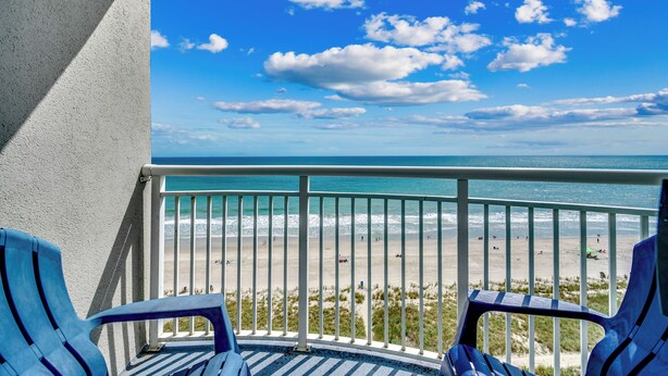 Ein Balkon mit Blick auf Strand und Meer.