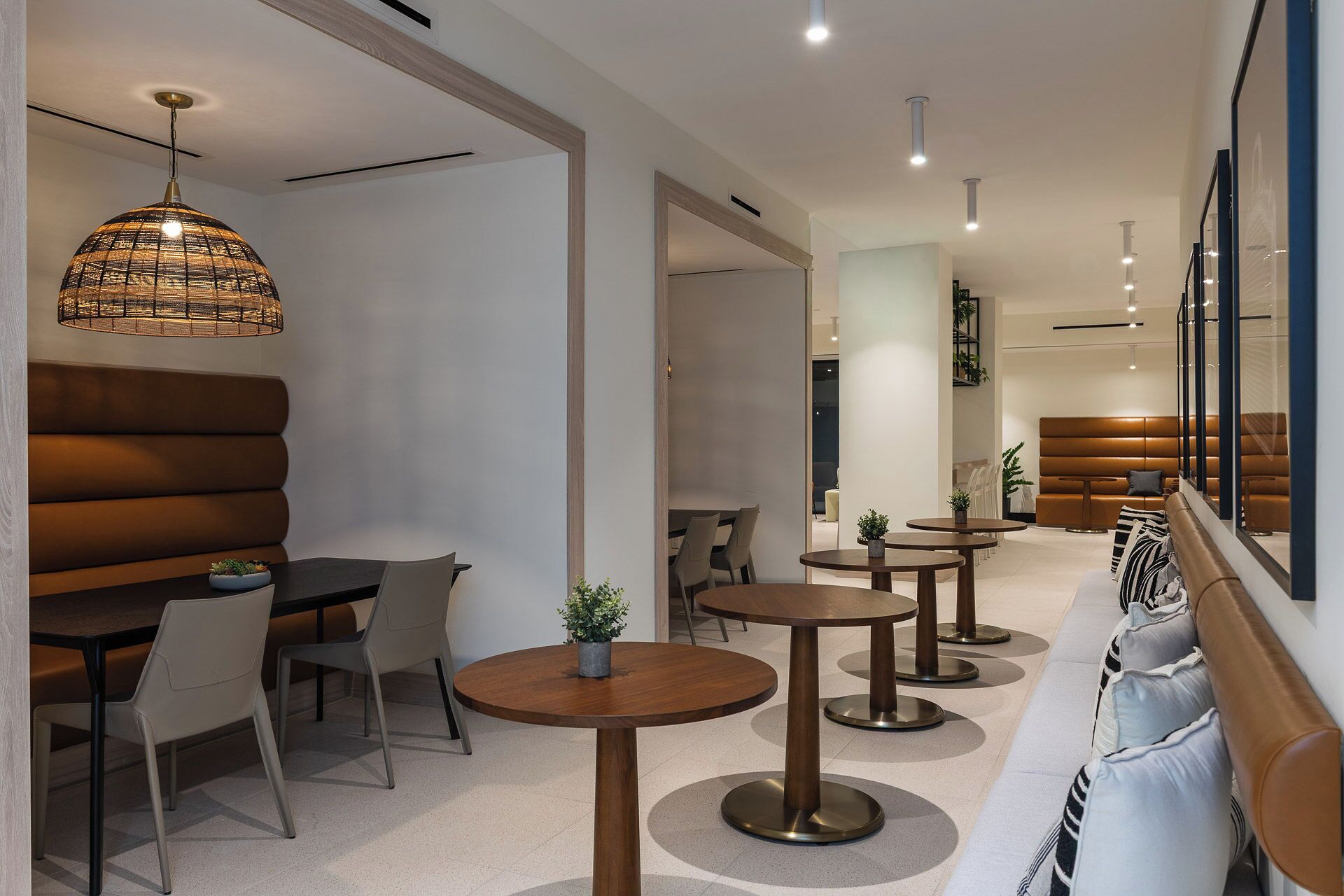 A modern interior with a seating area, tables, and a hanging light fixture.