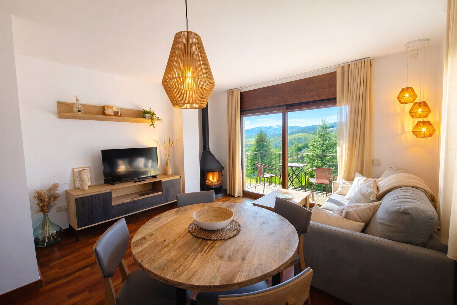 A modern living room with a TV, fireplace, dining table, and a sofa with a balcony view.