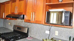 Una cocina con armarios de madera, una estufa de acero inoxidable y un microondas.