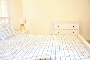 A bedroom with a bed, a nightstand, a lamp, and a dresser. - Comfortable and spacious apartment in Torre Alta (Puerto Plata)