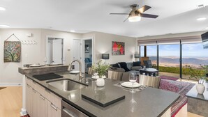 Een moderne keuken met een groot eiland, een eethoek en uitzicht op de bergen.