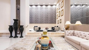 A modern lobby with a marble floor, a central coffee table with decorative items, a beige sofa, and a large mirror on the wall. - Aprts in a Condomin. 500m fr/ the Balneario Camboriu Ferris Wheel - Iors (Balneário Camboriú)