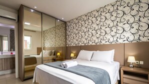 A modern hotel room with a large bed, bedside lamps, a mirror, and a patterned wall. - Aprts in a Condomin. 500m fr/ the Balneario Camboriu Ferris Wheel - Iors (Balneário Camboriú)