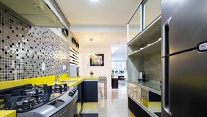 A modern kitchen with a stainless steel stove, a yellow countertop, and a tiled backsplash. - Aprts in a Condomin. 500m fr/ the Balneario Camboriu Ferris Wheel - Iors (Balneário Camboriú)
