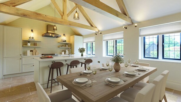Una cocina amplia con techos altos y vigas de madera a la vista, una isla central con taburetes de bar y un comedor con una mesa grande para seis personas.