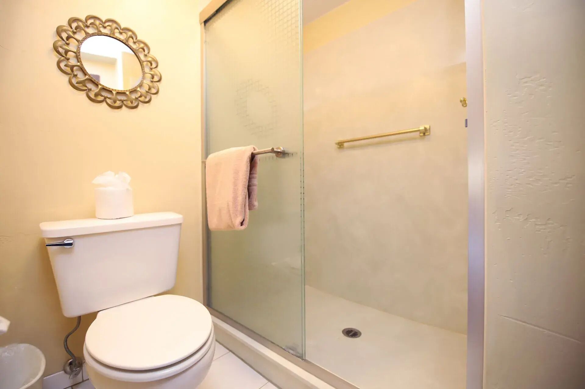 A bathroom with a toilet, a glass shower enclosure, and a towel rack.