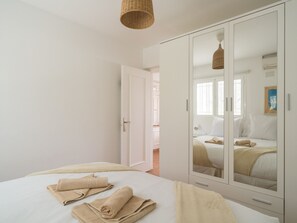 A bedroom with a large wardrobe, a bed with beige linens, and a hanging light fixture. - New Sweden By CanariasGetaway (San Bartolomé de Tirajana)
