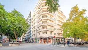 En byggnad med flera våningar, balkonger, ett övergångsställe och en parkeringsskylt.