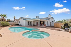 A backyard with a swimming pool, a covered patio, and a barbecue area. - Private Pool, Home Away From Home! (Bullhead City)