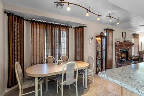 A dining area with a round table, chairs, and curtains. - Private Pool, Home Away From Home! (Bullhead City)