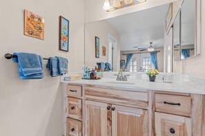 A bathroom with a wooden vanity, a large mirror, and blue towels. - Private Pool, Home Away From Home! (Bullhead City)
