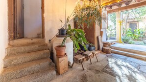 A rustic interior with stone steps, a wooden bench, and potted plants. - Historic Casona in Sierra de Gredos – Private Pool, 7 Bedrooms, 14 Guests (Candeleda)