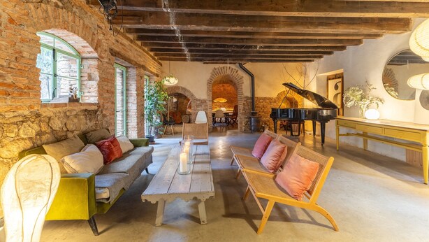 A rustic interior with exposed brick walls, wooden beams, a piano, and seating arrangements. - Historic Casona in Sierra de Gredos – Private Pool, 7 Bedrooms, 14 Guests (Candeleda)