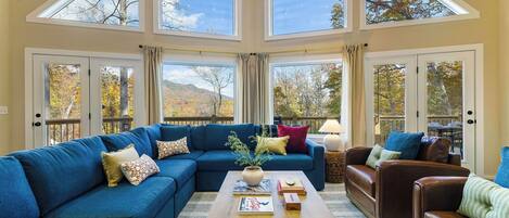 A spacious living room with a sectional sofa, a coffee table, and a fireplace.