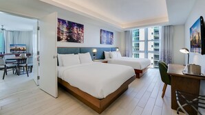 Una habitación de hotel moderna con dos camas, un escritorio y un comedor.