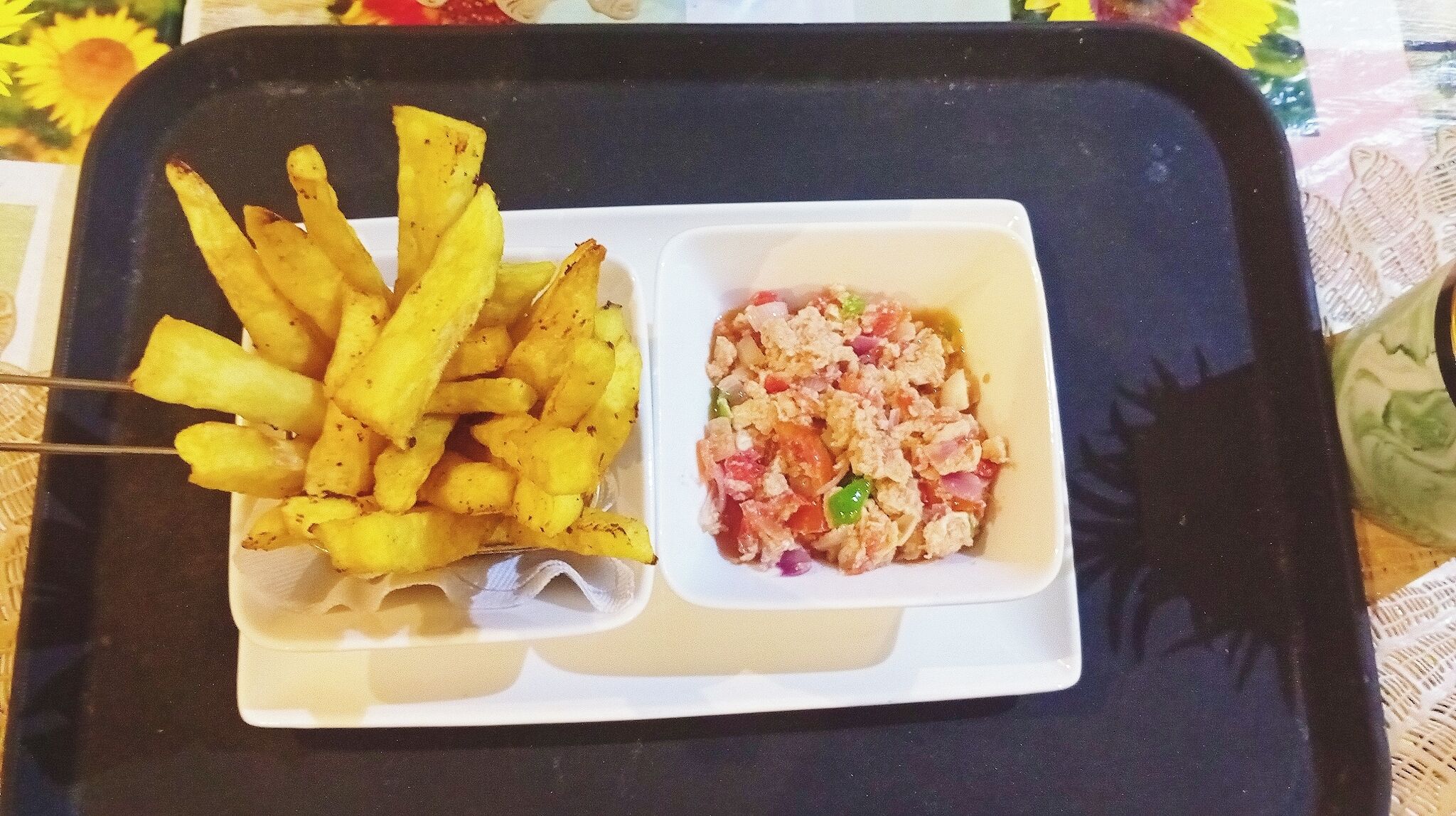 Un vassoio con patatine fritte e una piccola insalata mista.