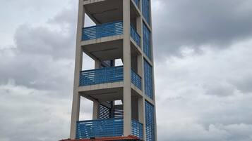 A multi-story building with balconies, a covered entrance, and a flat roof.